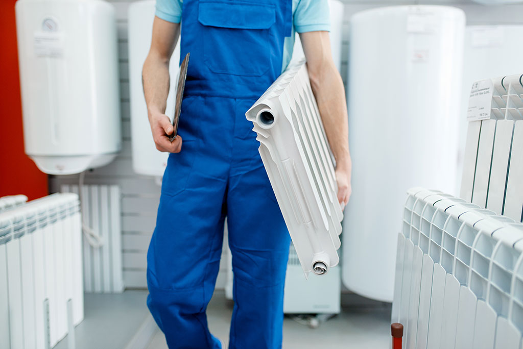 gas fast engineer holding radiator to install