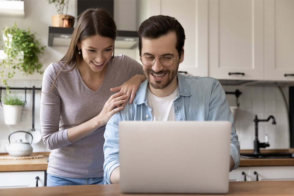 man and woman smiling at laptop gas fast