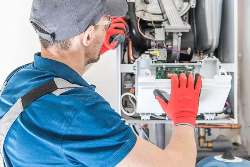 man inspecting boiler servicing