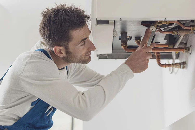 man fixing boiler with tool